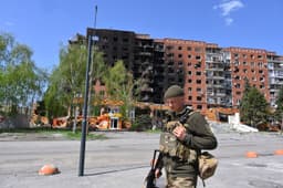 Na archívnej snímke z 23. apríla 2025 ukrajinský vojak prechádza okolo poškodených budov po útokoch ruskej armády v meste Pokrovsk. Foto: TASR/AP